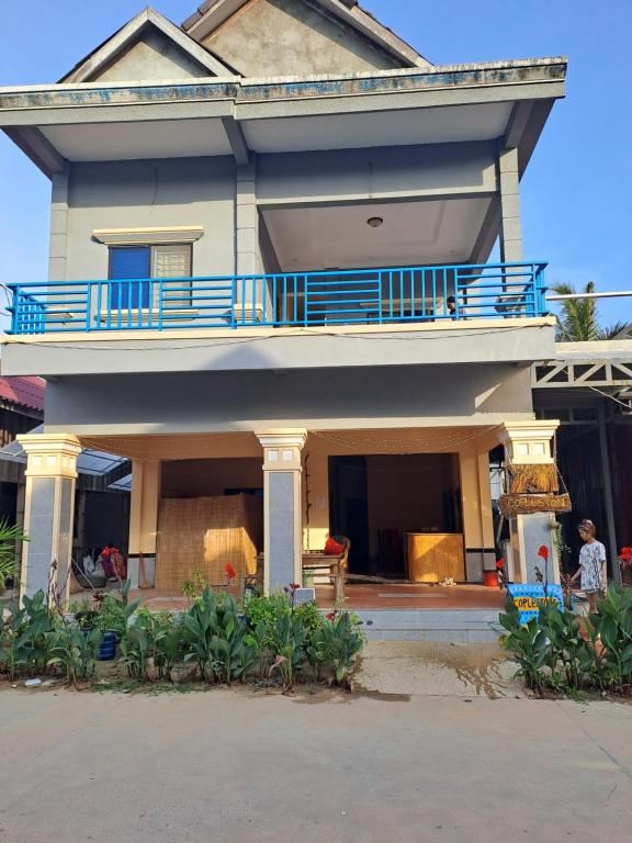 高龍撒冷島的住宿－Coplestone Hotel，大房子设有带蓝色栏杆的阳台