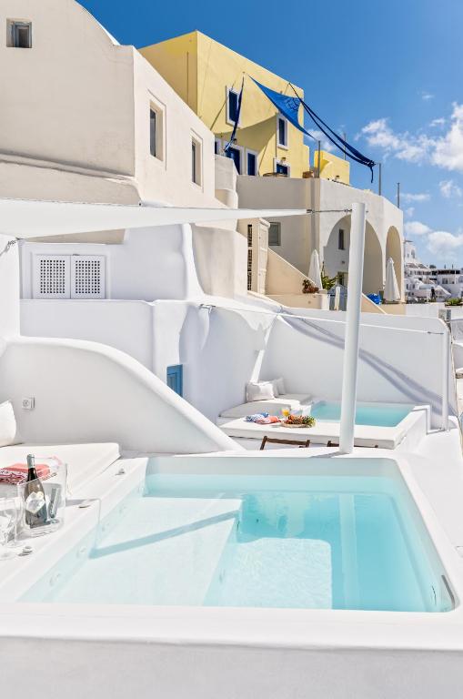 a view of the back of a white yacht with a swimming pool at Aristos Life Luxury Cave Villas in Oia