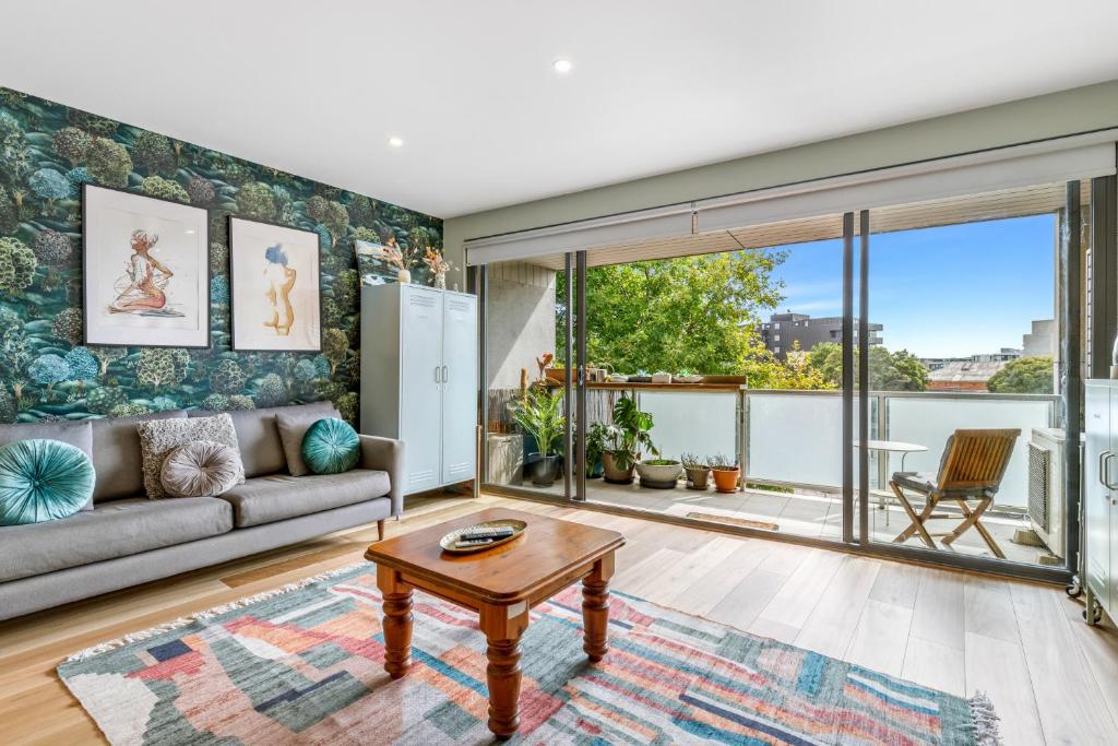een woonkamer met een bank en een tafel bij Quirky, Spacious & Sophisticated 2-Bed in St Kilda in Melbourne