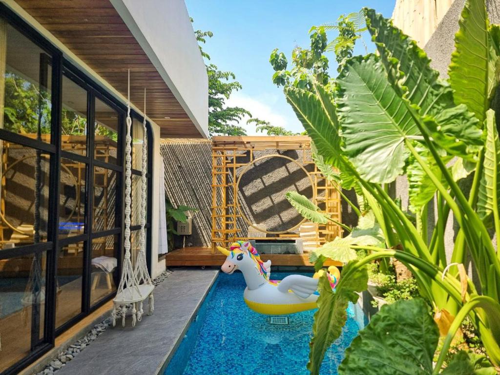 a backyard with a pool with a toy horse in it at Akaya Villas Solo in Kemiri