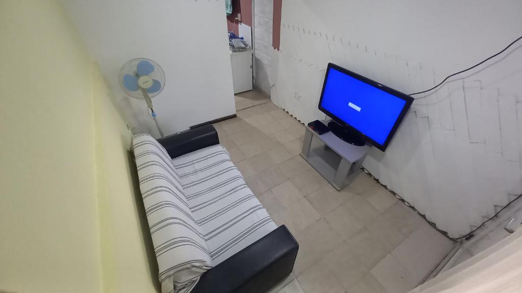 Habitación con sofá, TV y escritorio. en El Reciclado en Santa Rosa