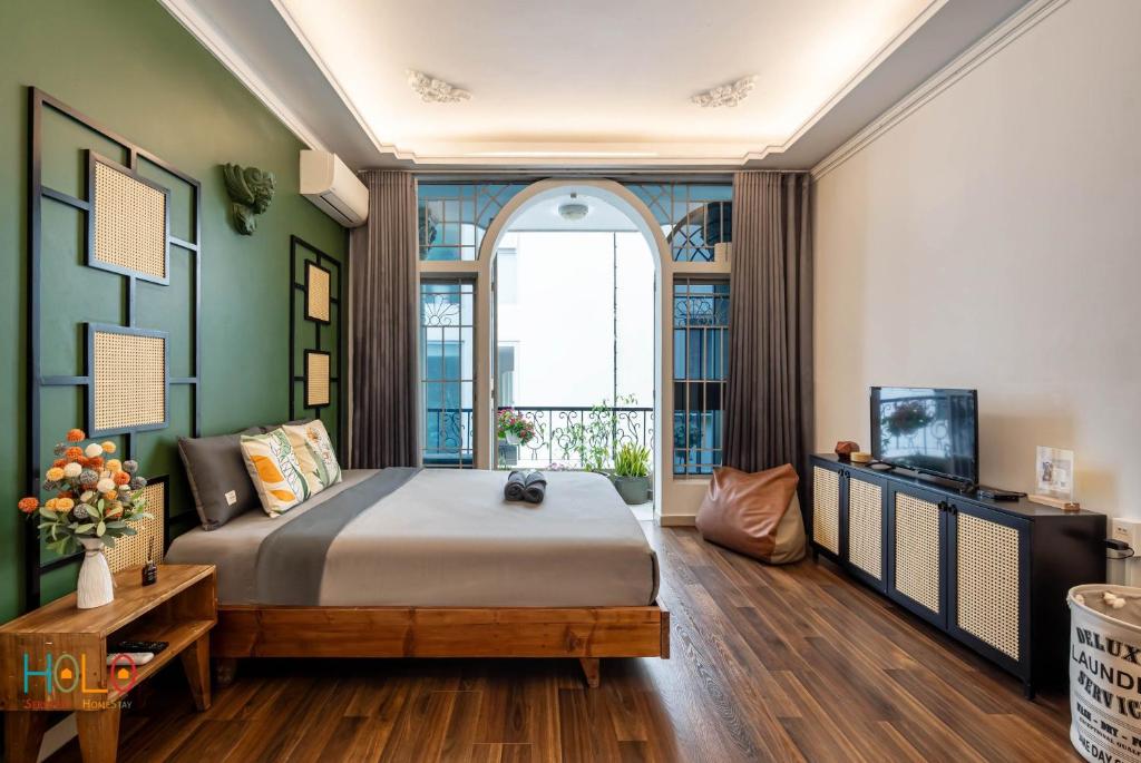 1 dormitorio con 1 cama y TV en HOLO LE THANH TON SAIGON Serviced HomeStay, en Ho Chi Minh
