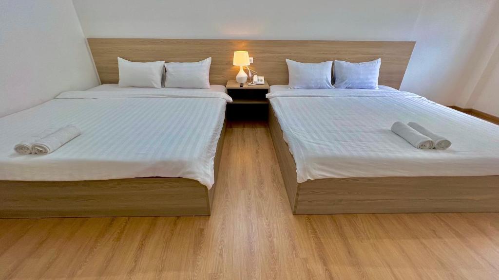 two beds sitting next to each other in a room at Bamboo Hotel Vung Tau in Vung Tau