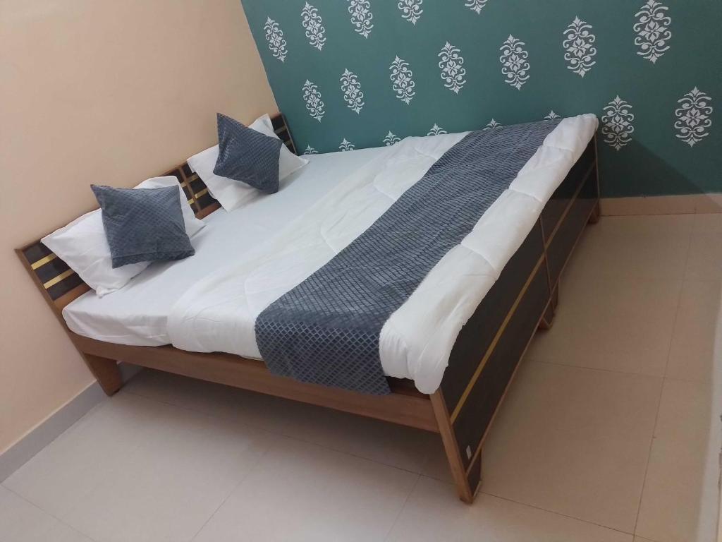 Bett mit blauen Kissen auf einem Zimmer in der Unterkunft OYO Hotel Shivay in Varanasi