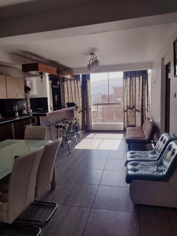 a living room with a table and chairs and a kitchen at Santiago in Tacna