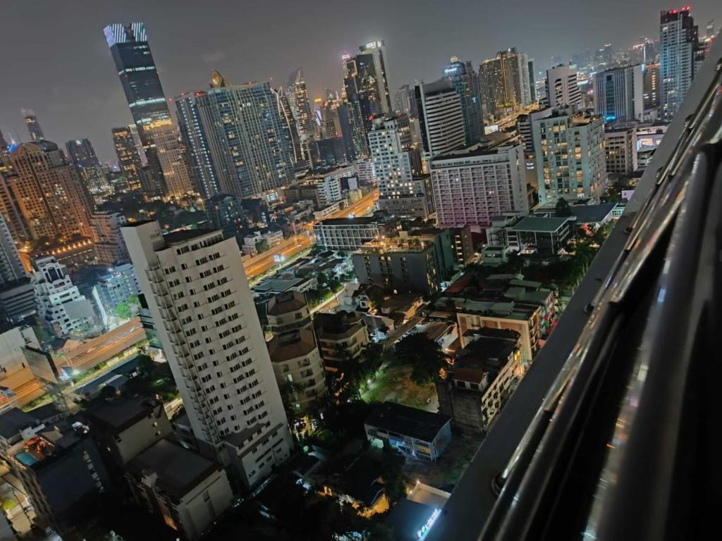 Omni Tower Sukhumvit Soi 4 Direct Rooms في بانكوك: أفق المدينة في الليل مع المباني الطويلة