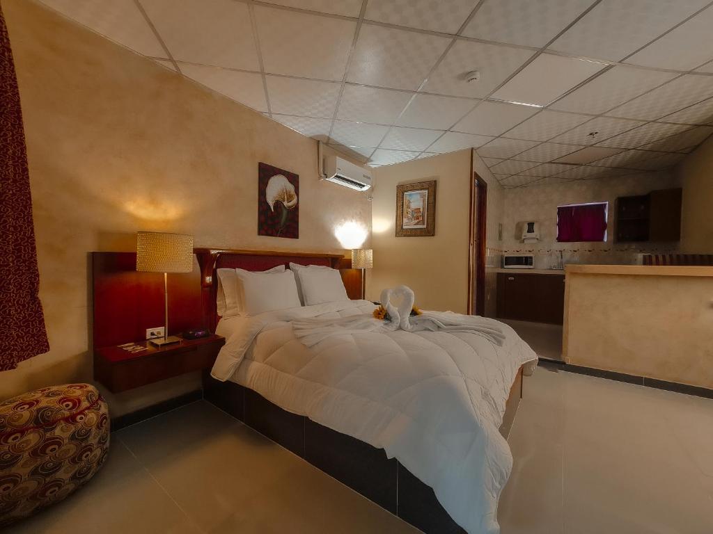 a bedroom with a large bed and a kitchen at Hotel Casa Miller in Panama City
