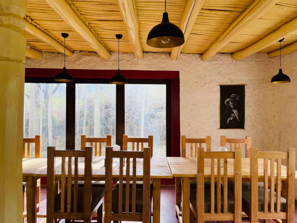 列城The Kesar Guest House Sumoor的配有木桌椅的餐厅