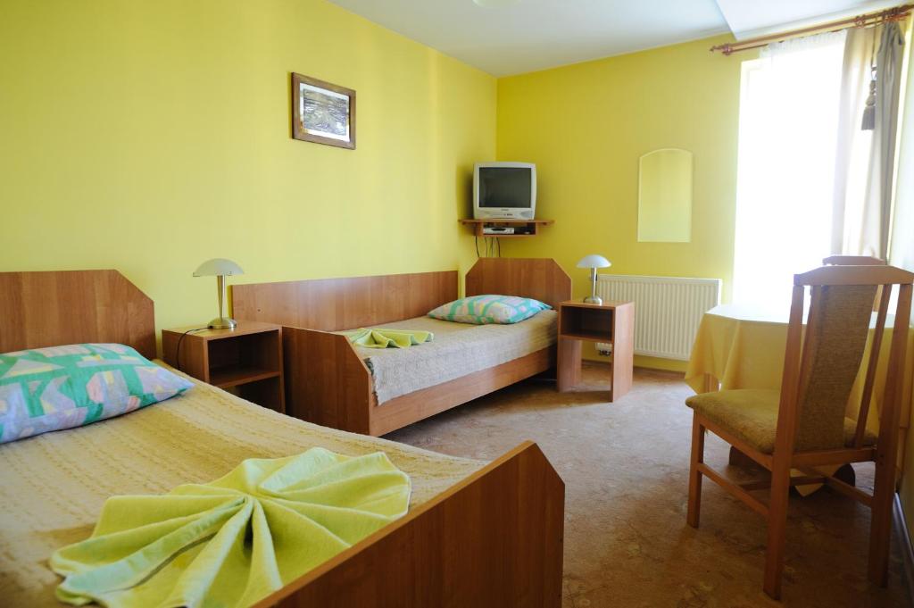 a hotel room with two beds and a tv at Villa Pan Tadeusz in Gdańsk