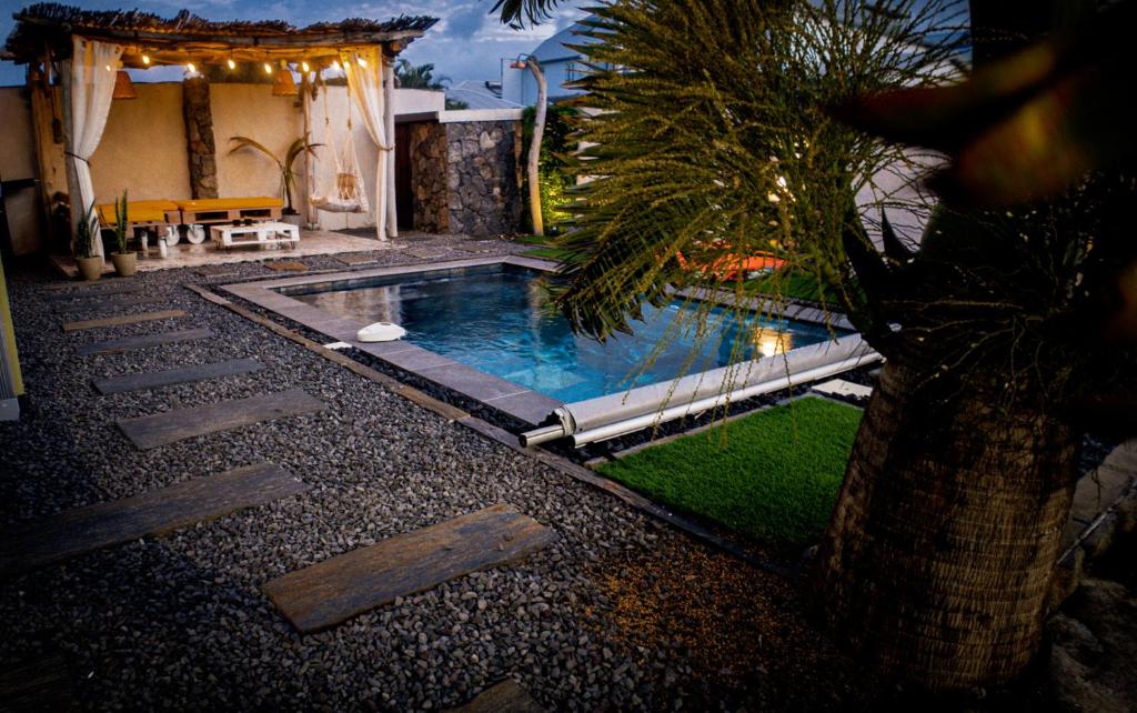 a swimming pool in the middle of a yard at Villa Osao Panahy in Le Patelin