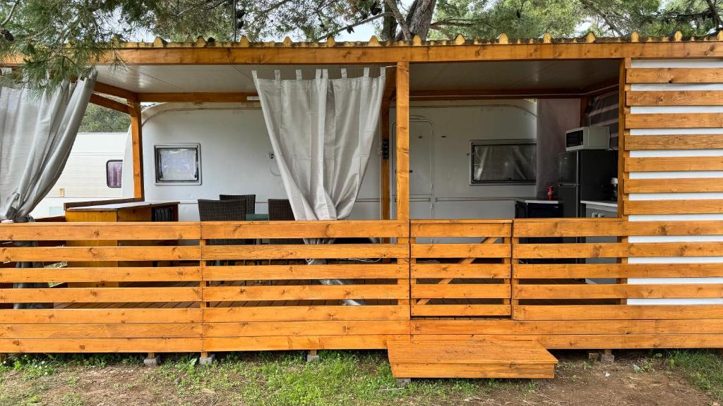 a wooden fence in front of a house at Adria Caravan (with air conditioner) in Privlaka