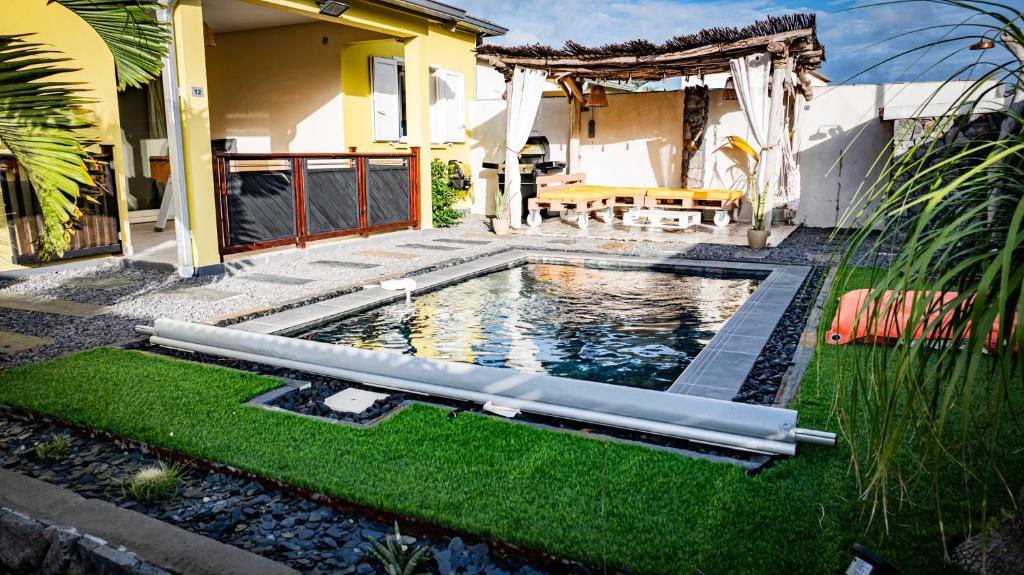 a swimming pool in the yard of a house at Villa Osao Panahy in Le Patelin