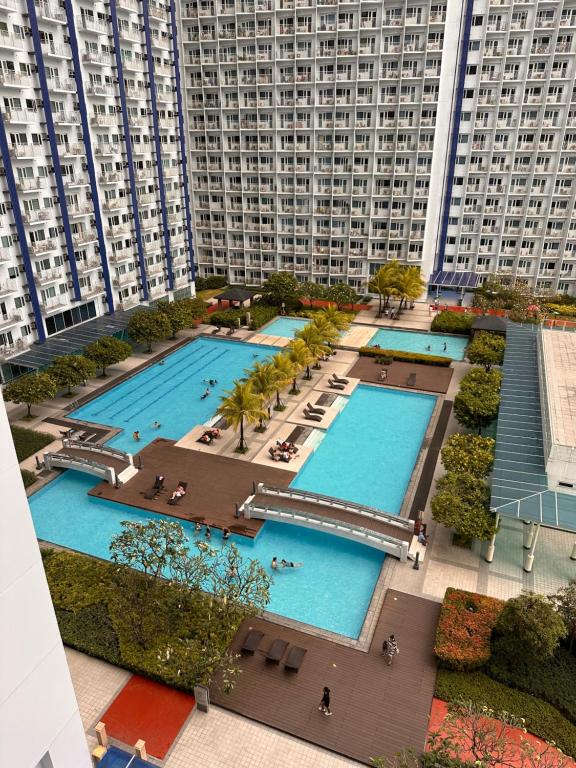 an overhead view of two pools in a city with tall buildings at Makati SM Jazz Residence Staycation Condo with balcony in Manila