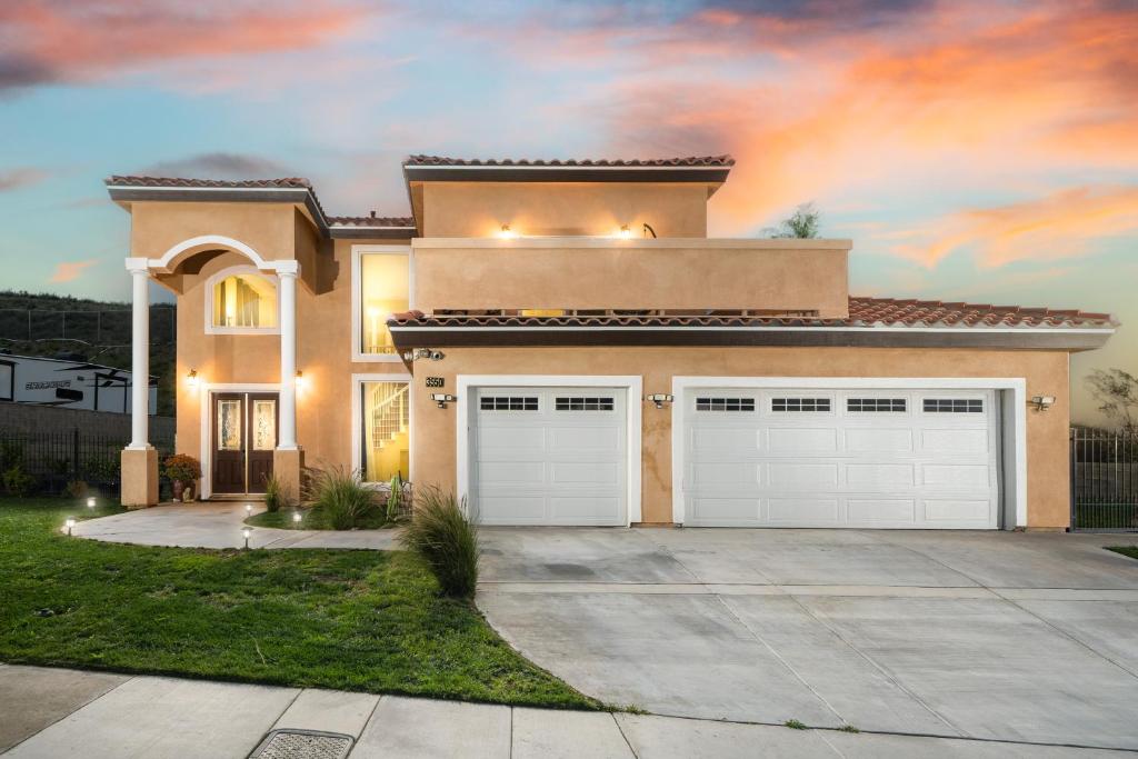 a house with two garage doors in a driveway at Luxurious Estate w/ Heated Pool and Amazing Views in San Bernardino