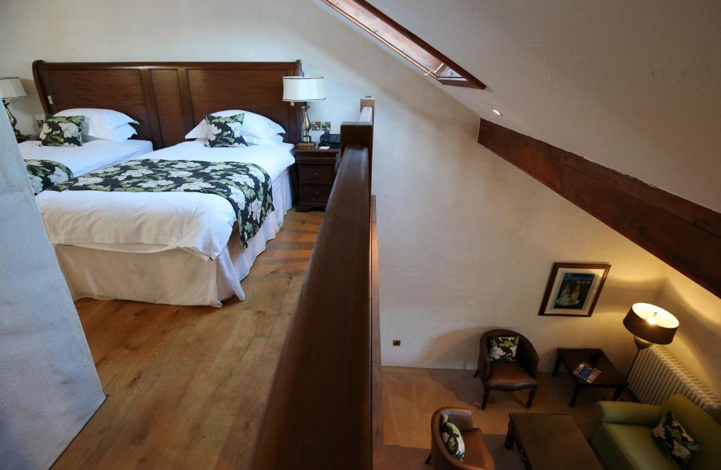 a bedroom with two beds and a stairway with a room with a stair at Bushmills Inn Hotel & Restaurant in Bushmills