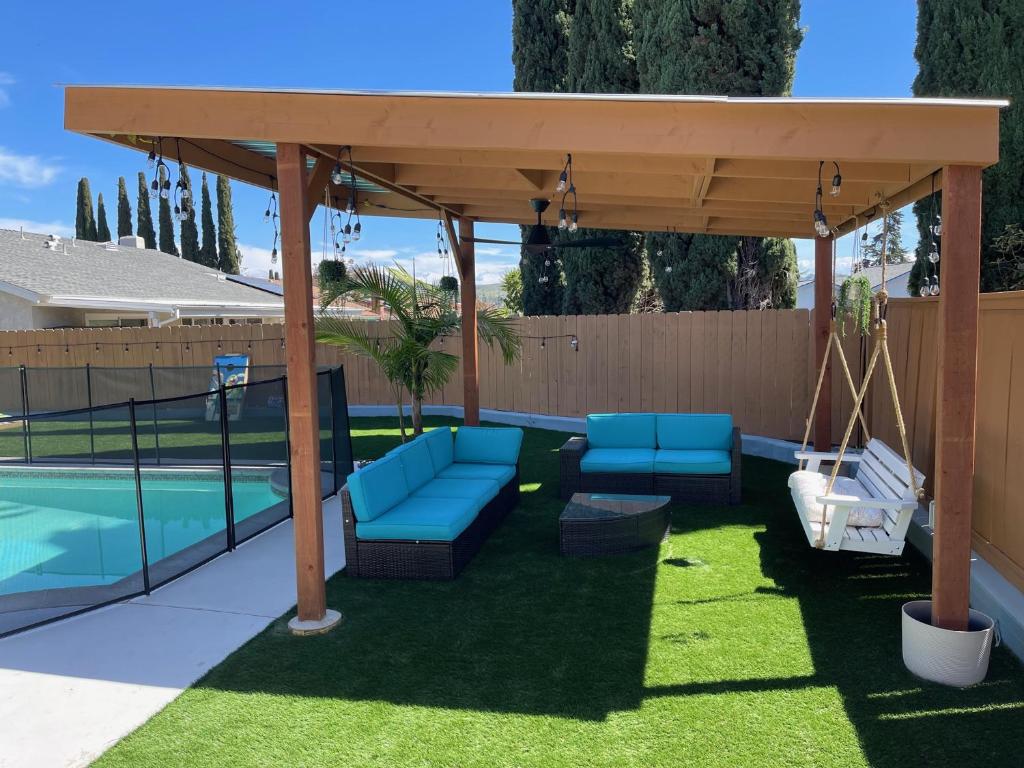 uma pérgola com cadeiras e um baloiço ao lado de uma piscina em Island in the Hills Modern Poolside Home in San Diego em San Diego