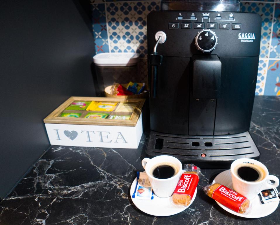 two cups of coffee sitting next to a coffee maker at Villa Osao Panahy in Le Patelin