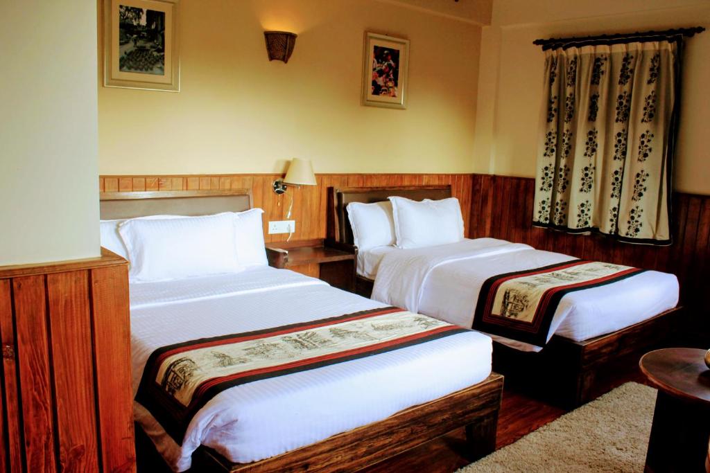 a hotel room with two beds and a table at Hotel Yechu in Bhaktapur