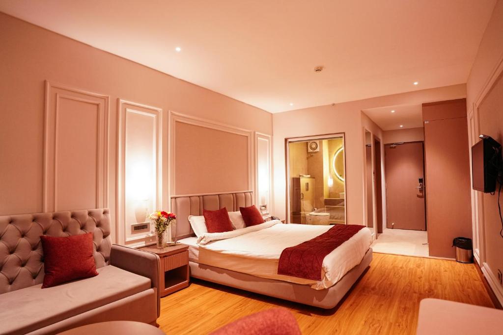 um quarto com uma cama grande e um sofá em ORSINO RESORT MALL ROAD em Darjeeling
