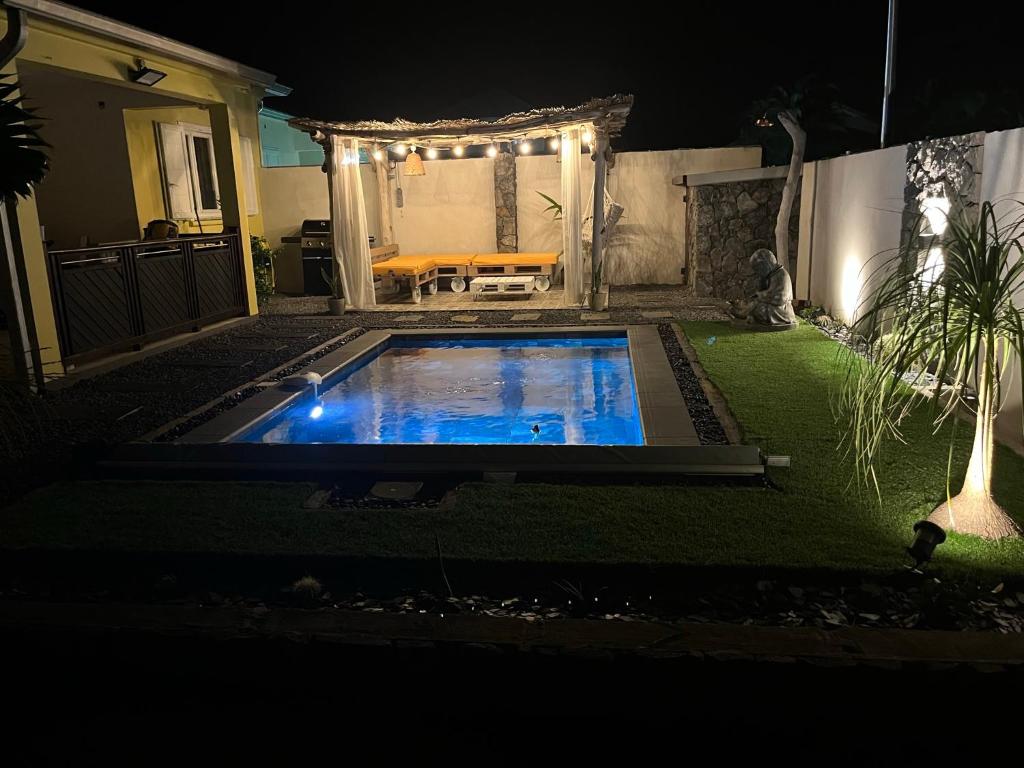 a small swimming pool in a yard at night at Villa Osao Panahy in Le Patelin