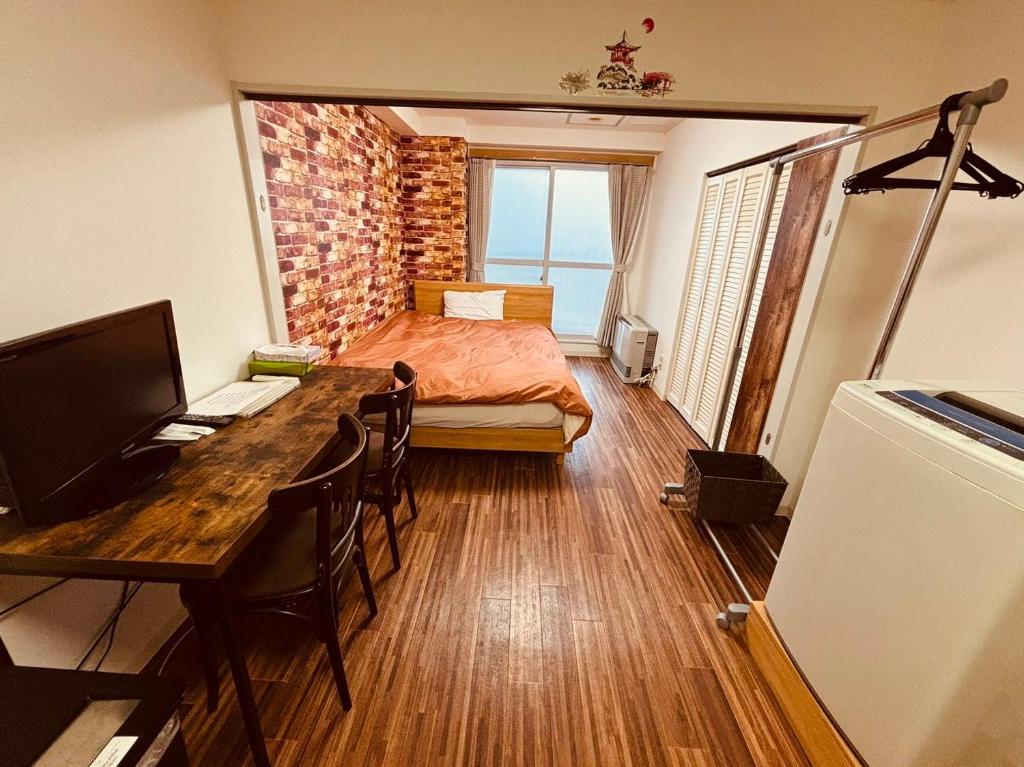 een slaapkamer met een bed en een bureau met een computer bij ローヤルハイツ菊水駅 in Sapporo