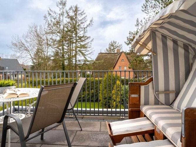 een patio met een tafel en stoelen en een hek bij Luxury holiday apartment in St Peter Ording in Böhl