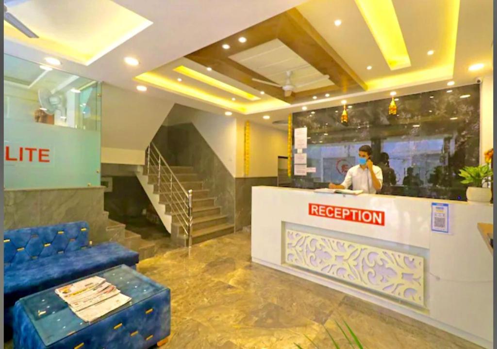 a man standing at a reception desk in a building at Hotel Gloory Suites Near Delhi Airport in New Delhi