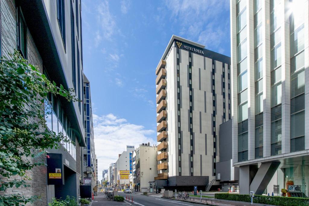 une rue urbaine avec de grands bâtiments dans une ville dans l'établissement Hotel Vista Nagoya Nishiki, à Nagoya