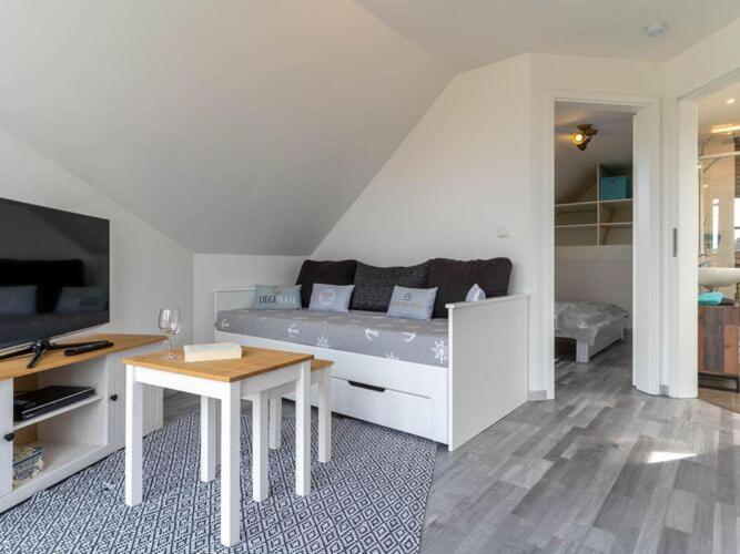 a living room with a bed and a table at Ferienwohnung in St Peter Ording in Sankt Peter-Ording