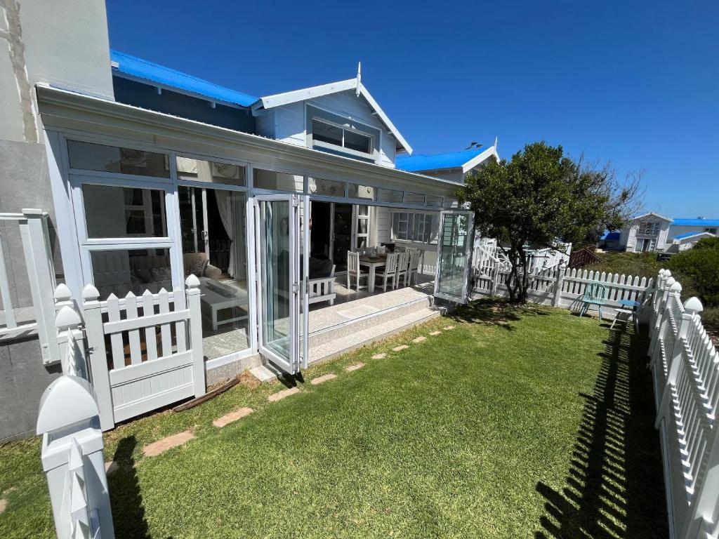 a house with a white fence and a yard at Pinnacle Lodge 1089 in Dana Bay