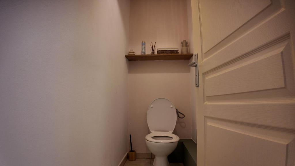 a bathroom with a white toilet and a door at Villa Osao Panahy in Le Patelin