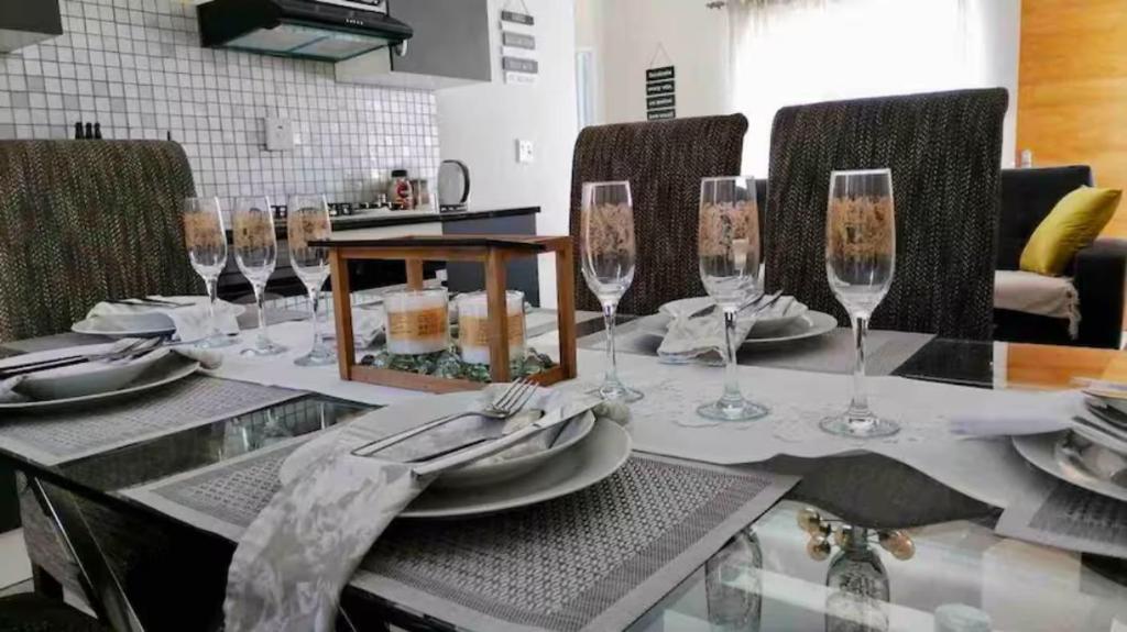 stół z kieliszkami do wina i talerzami w obiekcie Evans Village - Stunning Apartments w mieście Johannesburg