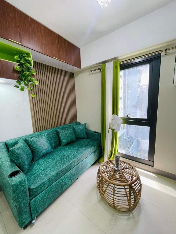 a green couch in a living room with a window at Studio 7 in Manila