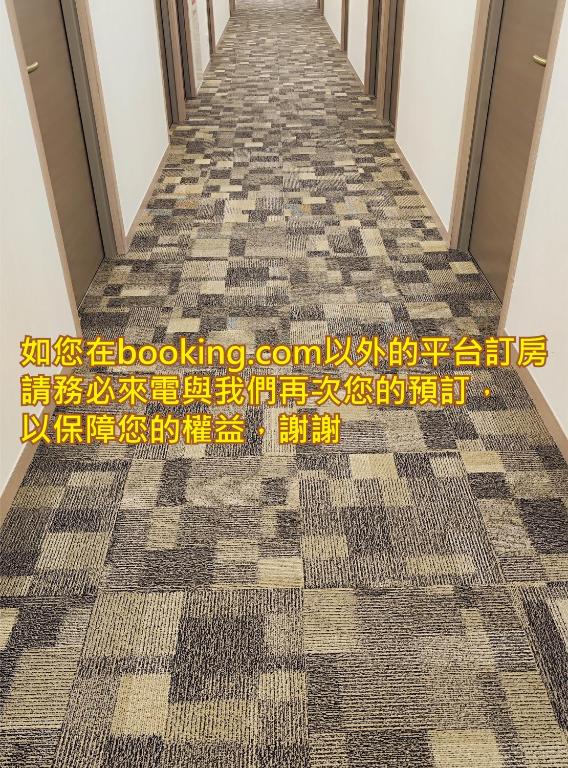 a hallway of a building with a checkered floor at Harmonious Hotel in Kaohsiung
