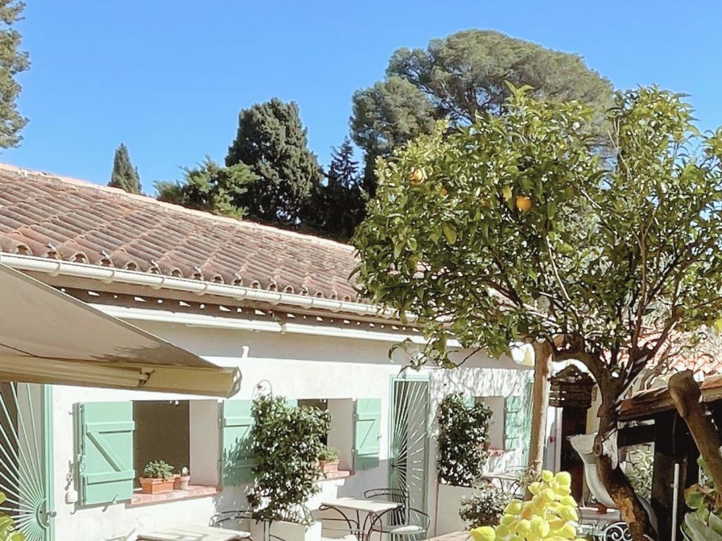 a white house with a tree and a patio at La Jabotte Boutique Hotel in Antibes