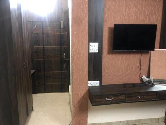 Zimmer mit einem TV an der Wand in der Unterkunft Blessings Lounge in Saharanpur