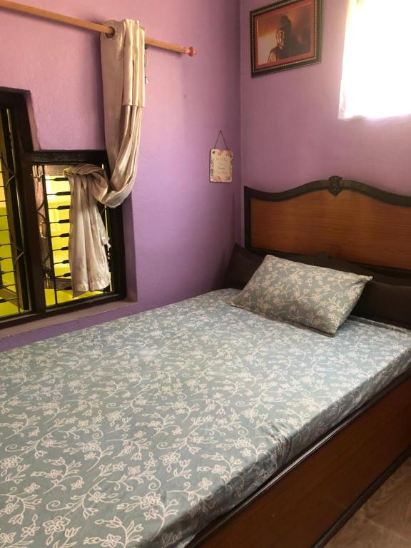 een slaapkamer met een bed met paarse muren en een raam bij Diamond Home Stay - Private Rooms in Kathmandu