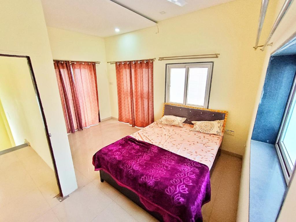 a bedroom with a bed with a purple blanket at CityAir in Pune