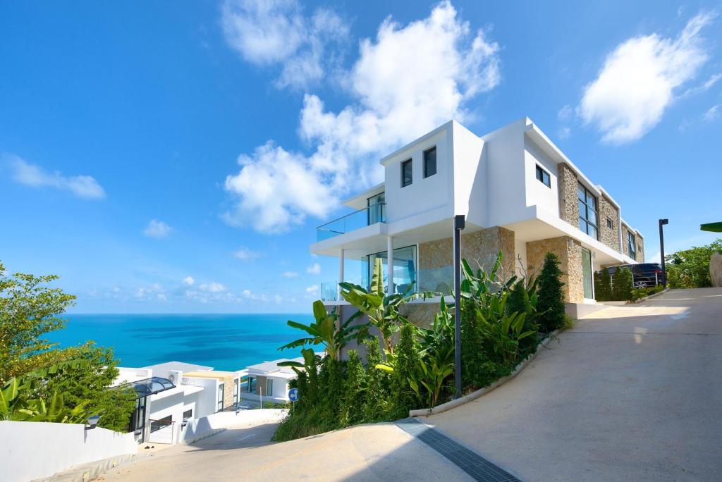 a white house with the ocean in the background at Villa The Wave 2 Residence in Lamai