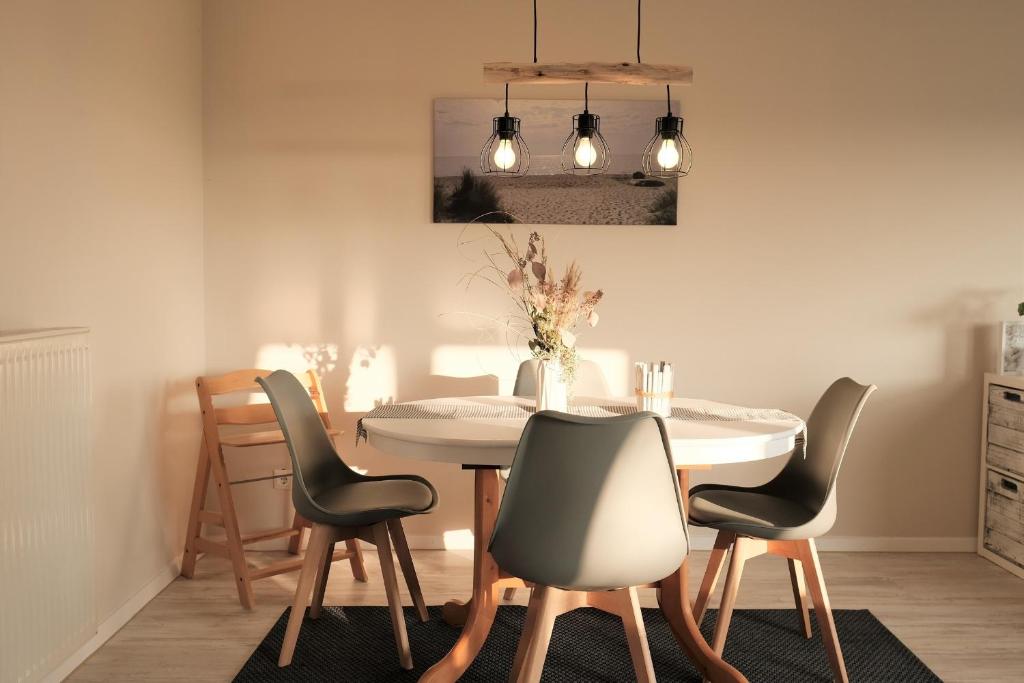 une salle à manger avec une table et des chaises blanches dans l'établissement FEWO Ostseeland, à Grömitz