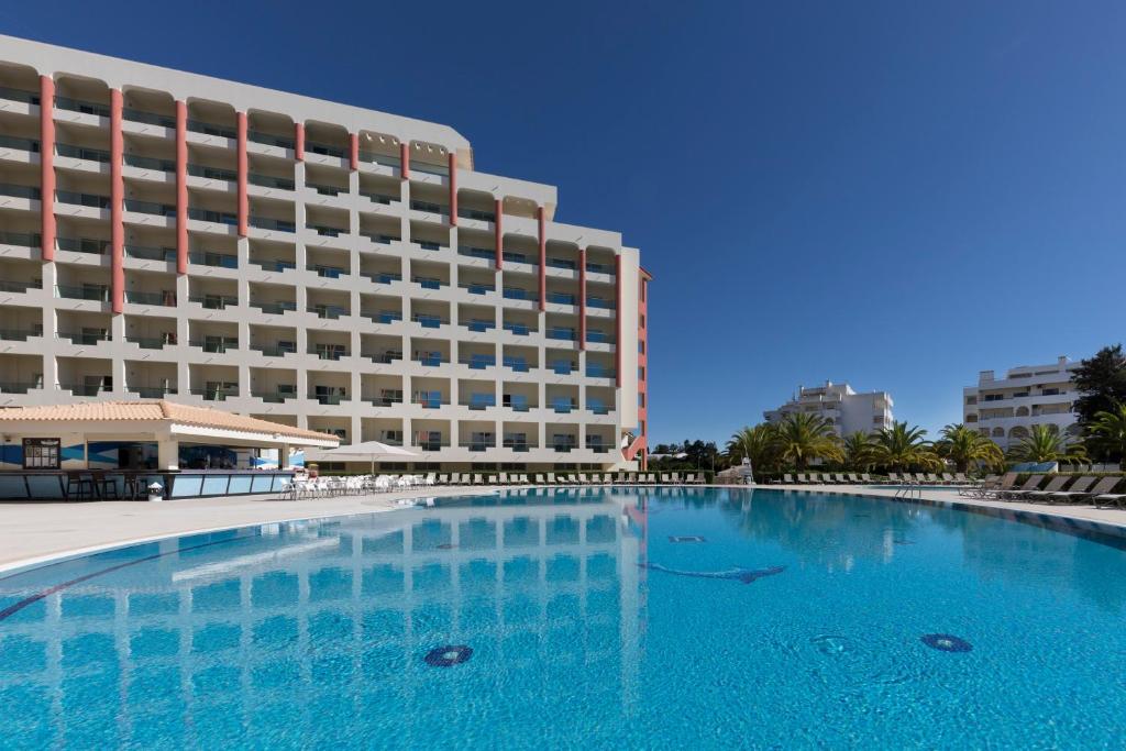 une grande piscine en face d'un hôtel dans l'établissement Ukino Palmeiras Village - 24h All Inclusive, à Armação de Pêra