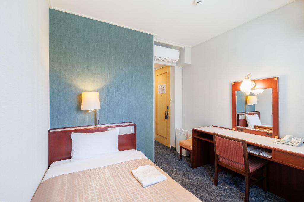 Postel nebo postele na pokoji v ubytování Hiroshima Intelligent Hotel Annex