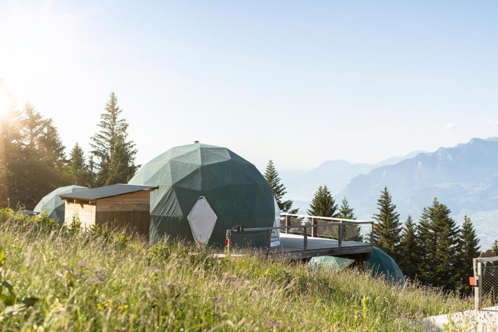 uma tenda de cúpula verde no topo de uma colina em Whitepod Original em Monthey