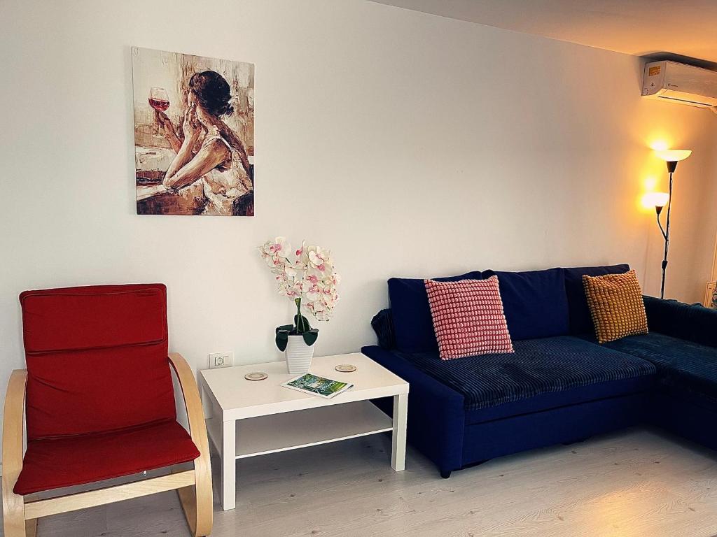 a living room with a blue couch and a table at Close to the Airport 15 minutes walk & Therme -SELF CHECK-IN in Otopeni