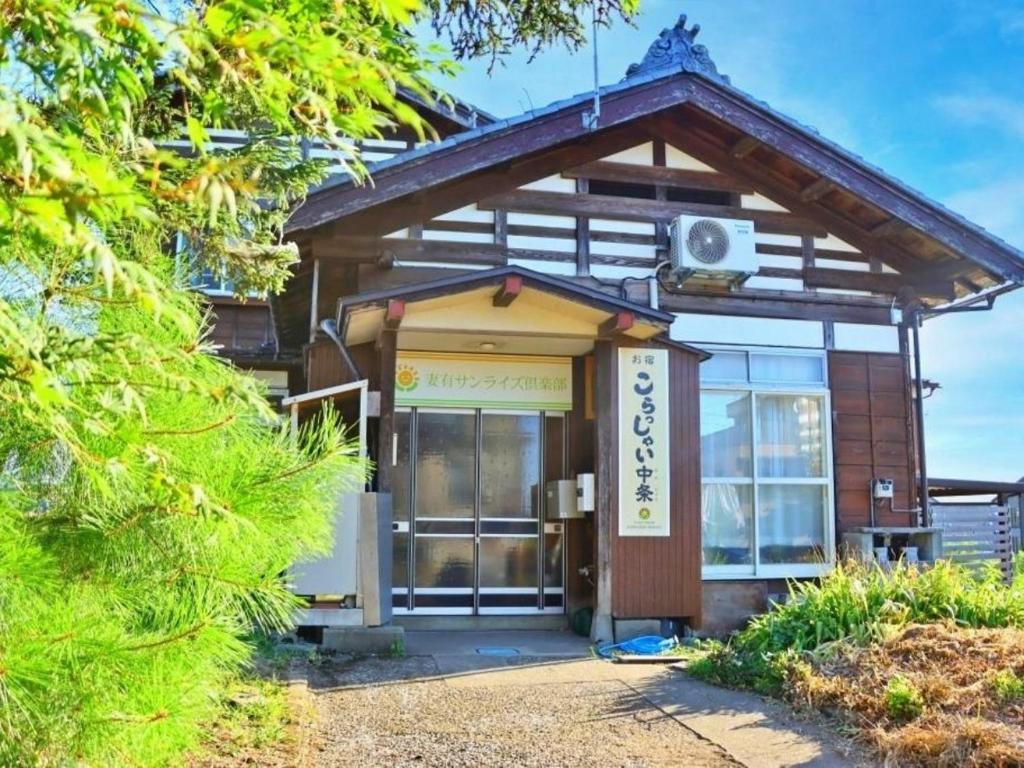 ein Gebäude mit einem Schild davor in der Unterkunft Guest House Korasshai Nakajo in Tōkamachi