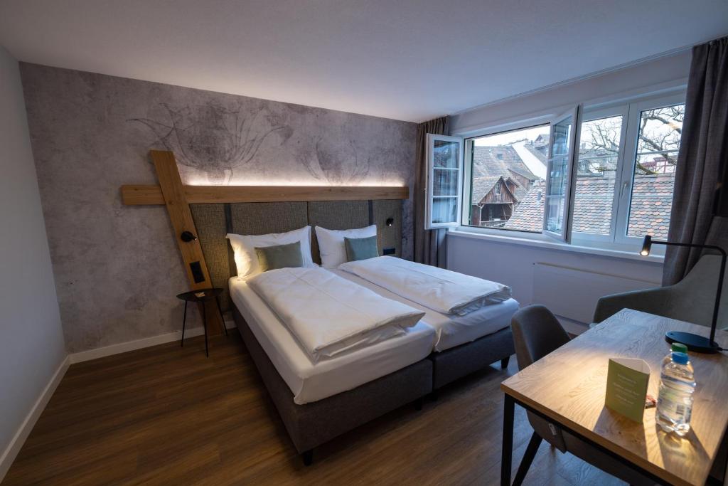 een slaapkamer met een bed en een kruis aan de muur bij Hotel Adler in Stein am Rhein
