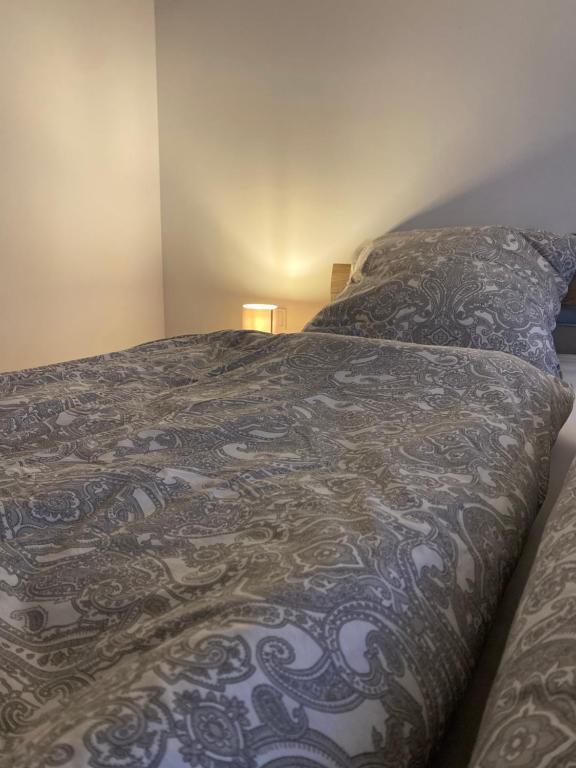 un letto in una camera da letto con una coperta sopra di PrimeBnb Bad Hersfeld a Bad Hersfeld