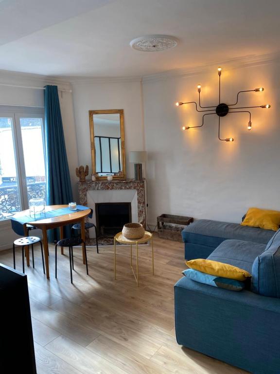 - un salon avec un canapé bleu et une table dans l'établissement Disneyland & Paris - JO 2024 - 4 personnes, à Crécy-la-Chapelle