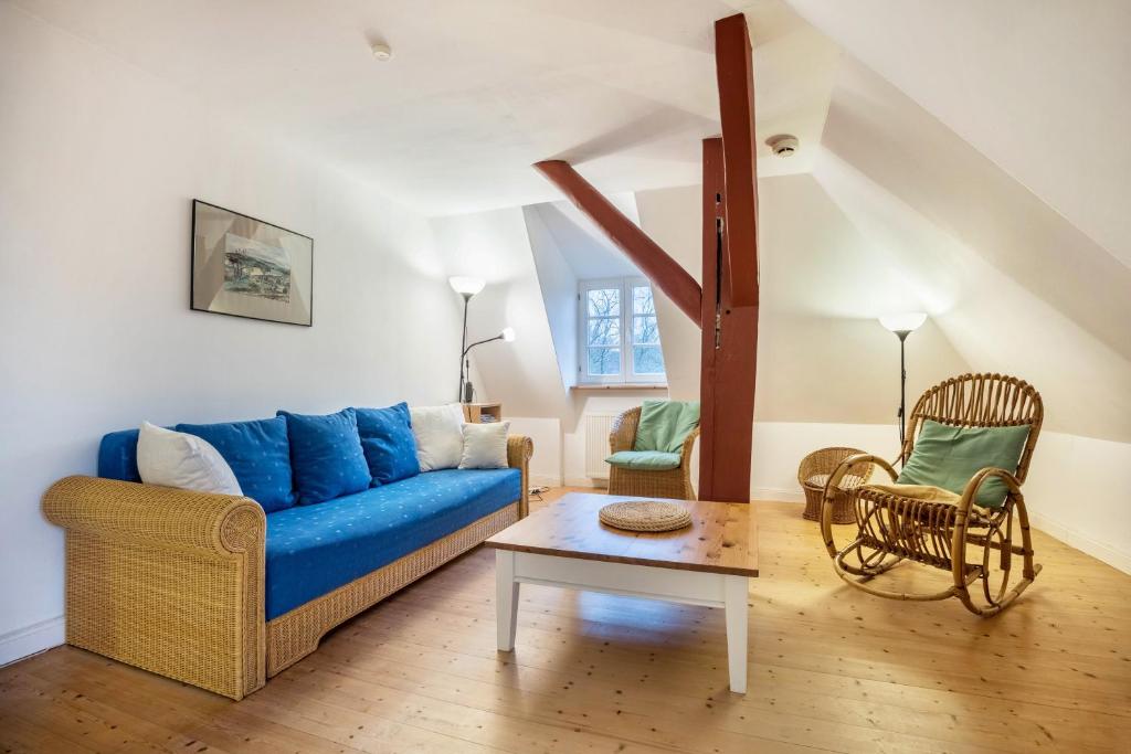 - un salon avec un canapé bleu et une table dans l'établissement Wohnung Kemenate, à Trendelburg