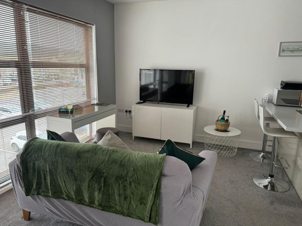 een woonkamer met een bank en een flatscreen-tv bij Harbourside Apartment - 1 Bed Apartment in Whitehaven